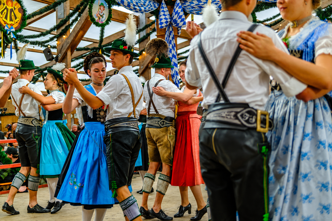Couple wearing Bavarian lederhosen and dirndl at Oktoberfest