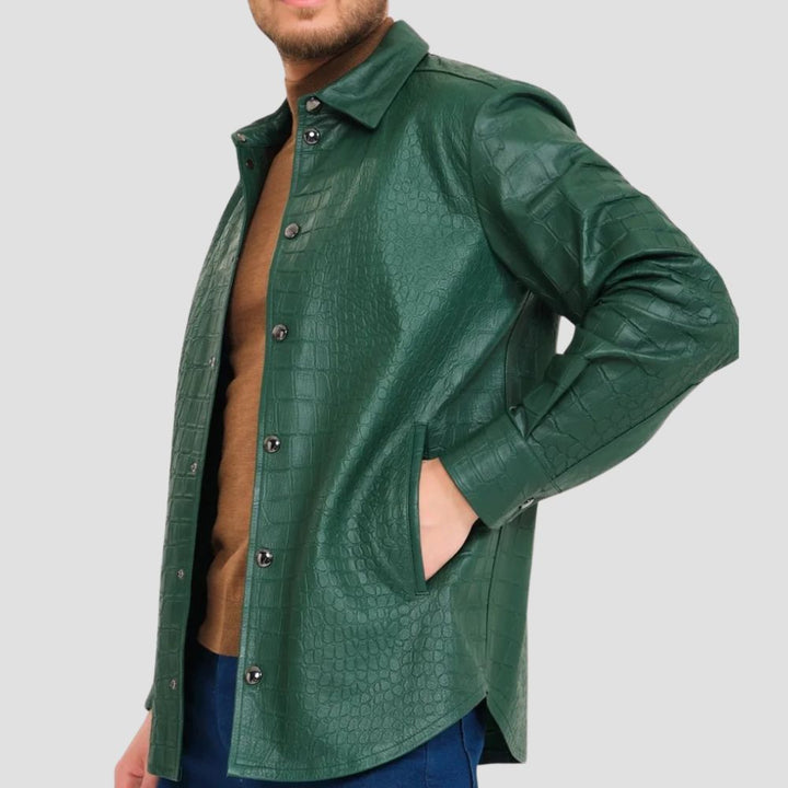 A man wearing a trendy green crocodile-embossed leather shirt paired with black trousers.